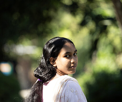 Ria draußen in ihrer Gemeinde stehend in Bangladesch