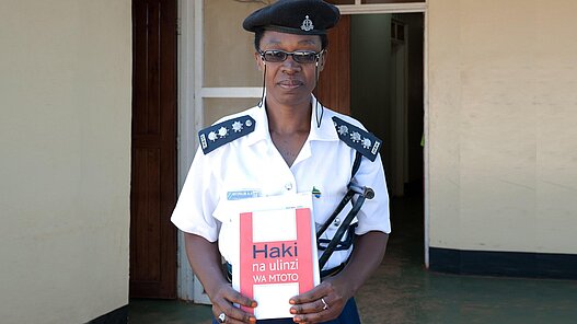 Mit diesem Betrag unterstützen Sie die Schulung einer Polizistin oder eines Polizisten. Polizistin in der Provinz Geita mit einer Broschüre "Rechte und Schutz von Kindern".
