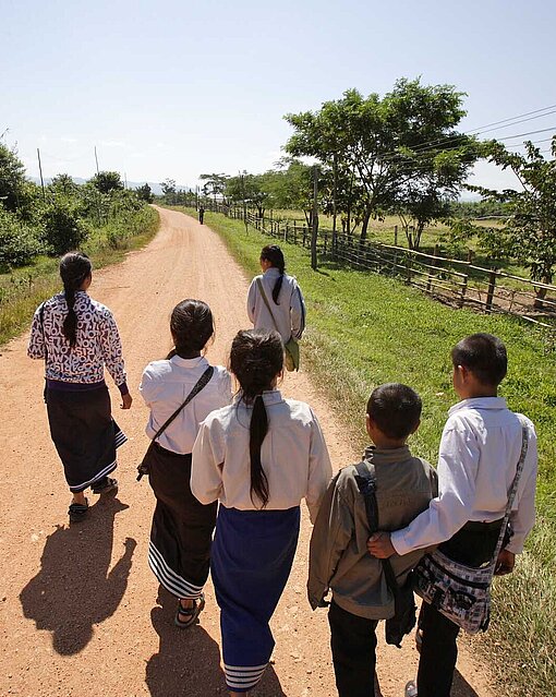 Kinder auf dem Schulweg im laotischen Bokeo Kinder laufen auf einem Weg