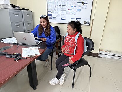 Zwei Frauen sitzen in einem Büro. Eine der Frauen ist am Laptop und die andere Frau ist schwanger und sitzt daneben.