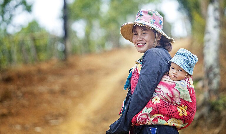 Mutter mit kleinem Kind im Arm in Vietnam