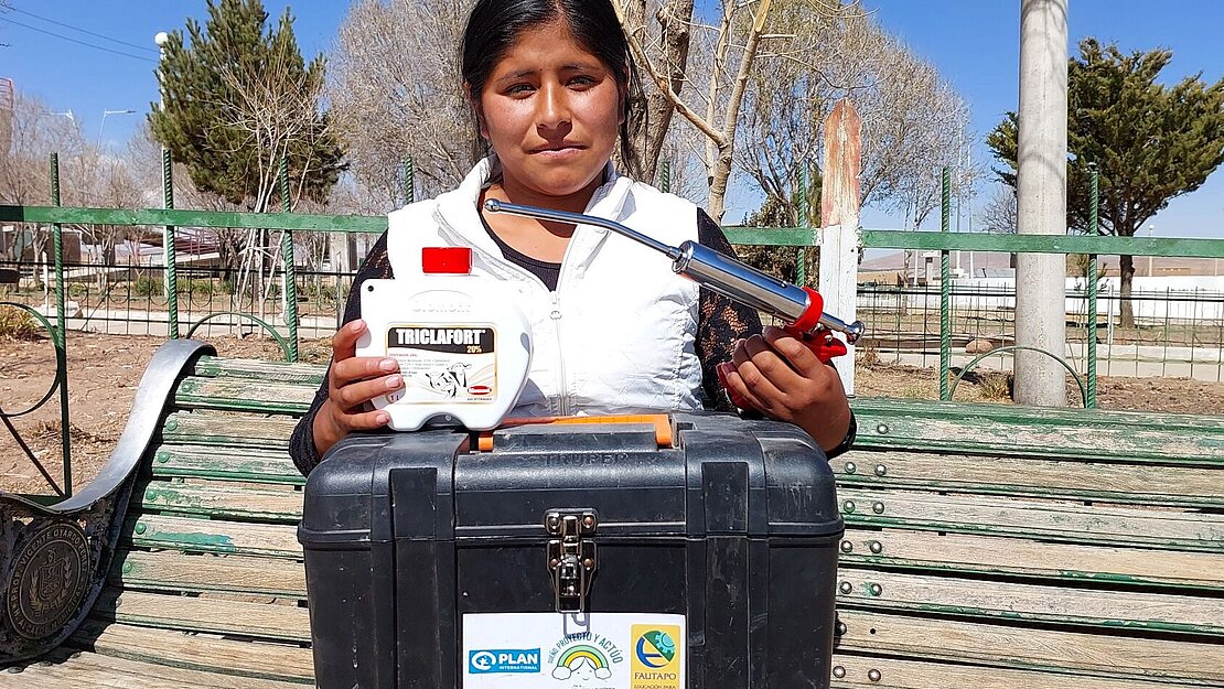 Eine Jugendliche hat ein Gerät zur Entwurmung von Wiederkäuern in der Hand