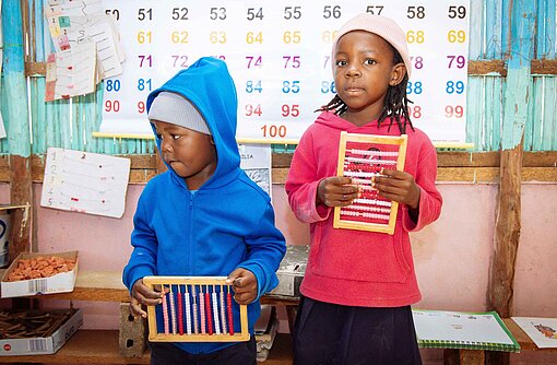 Im Kinderhort werden unter anderem altersgerechte Aufgaben rund um das kleine Einmaleins angeboten Kinder mit einem Rechenschieber