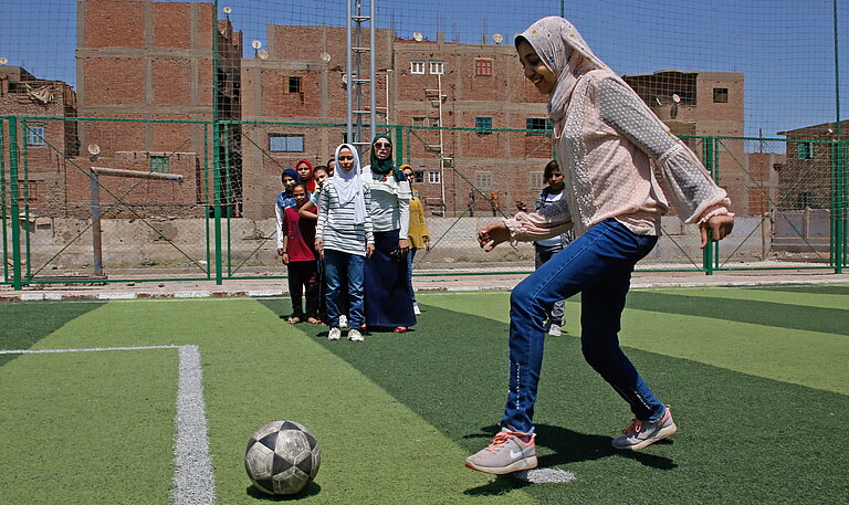 Menschen spielt Fußball auf Platz in der Stadt.