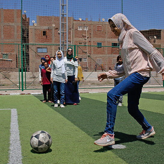 Menschen spielt Fußball auf Platz in der Stadt.