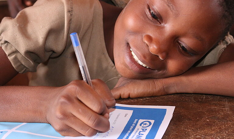 Ein Mädchen in Benin schreibt einen Brief an seine Pateneltern.