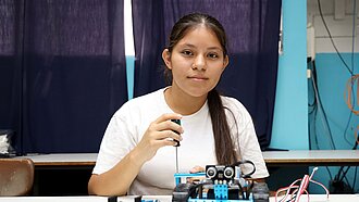 Mädchen schraubt an einem Roboter