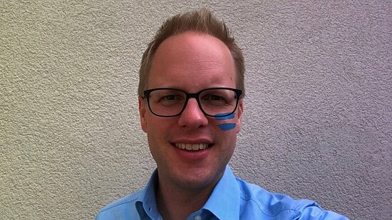 Jens Brandenburg mit dem blauen Girls Get Equal-Gleichzeichen auf der Wange.
