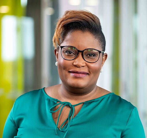 Edell Otieno Okoth ist FGM-Expertin bei Plan International Deutschland Eine Frau mit grünem Kleid