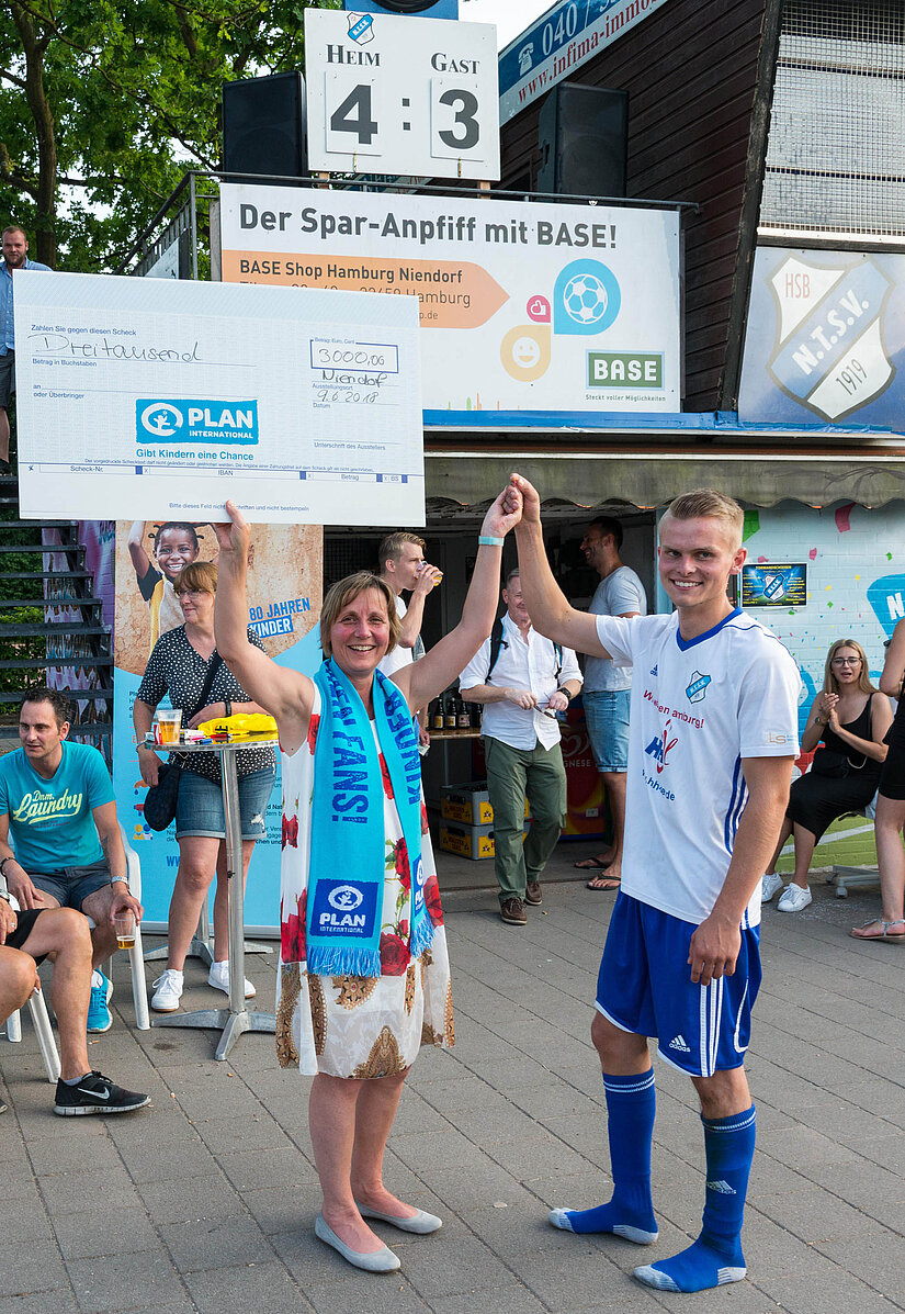 Organisator Lennart Ludwig übergab den Spenden-Scheck an Maike Röttger, Vorsitzende der Geschäftsführung von Plan International Deutschland. © Ole Ludwig