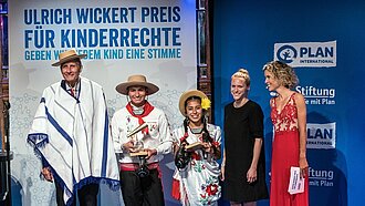 Ulrich Wickert mit den Jugendpreisträgerinnen aus Bolivien, Jhordan und Paola, sowie Verena Sailer und Moderatorin Annika Zimmermann. (v.l.n.r) © Plan International/Michael Fahrig