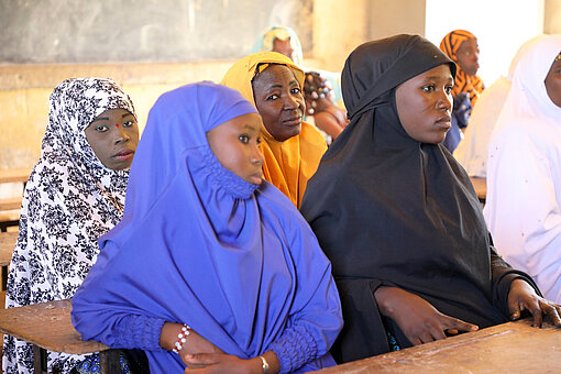 Mehrere Mädchen sitzen in einem Klassenzimmer und höre aufmerksam zu