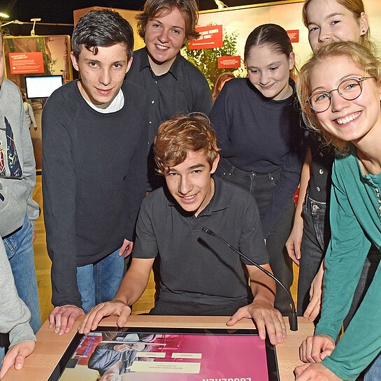 Jugendliche einer Schulgruppe besuchen die Ausstellung Mission 2030 von Plan Internationel Deutschland