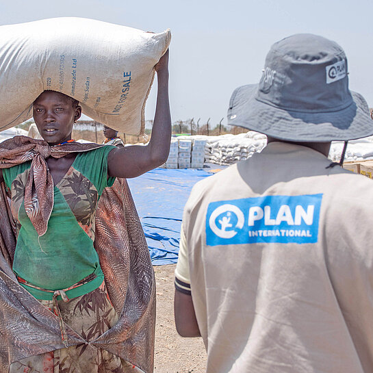 In Südsudan verteilen Plan-Teams Nahrungsmittel an bedürftige Frauen und Familien
