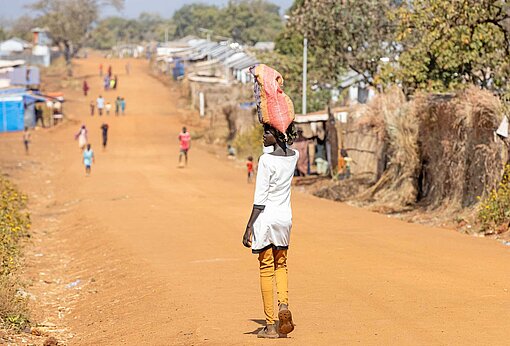 Blick auf eine sandige Straße umgeben von Hütten 