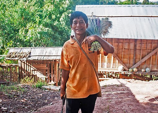 Bauer Luang (54) erlebt in Laos jährliche Ernteeinbußen Ein Mann mit Landwirtschaftsgerät