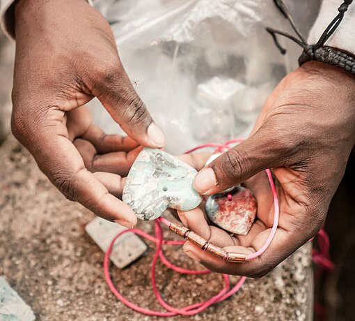 Nahaufnahme einer Kette mit einem herzförmigen Anhänger aus poliertem Stein.
