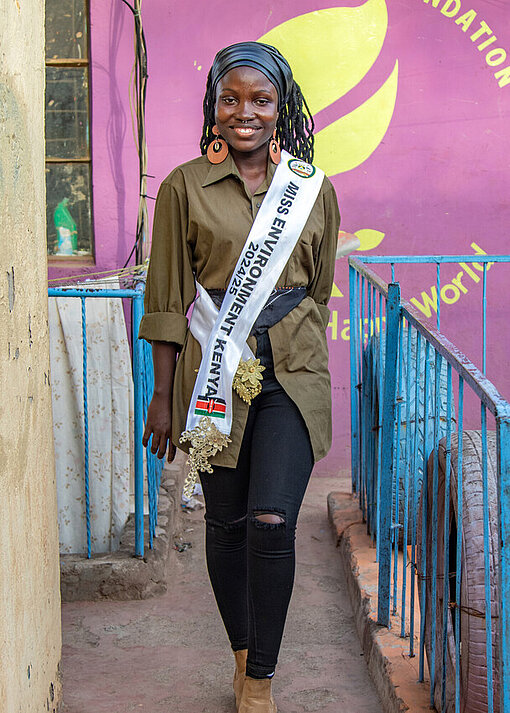 Faith in Kenia eine Bandschleife tragend