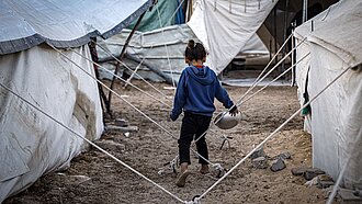 Ein Kind zwischen Zelten im Gazastreifen