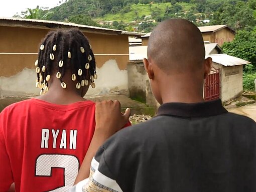 Ein junger Mann hat seine Hand auf die Schulter einer jungen Frau gelegt, sie laufen gemeinsam