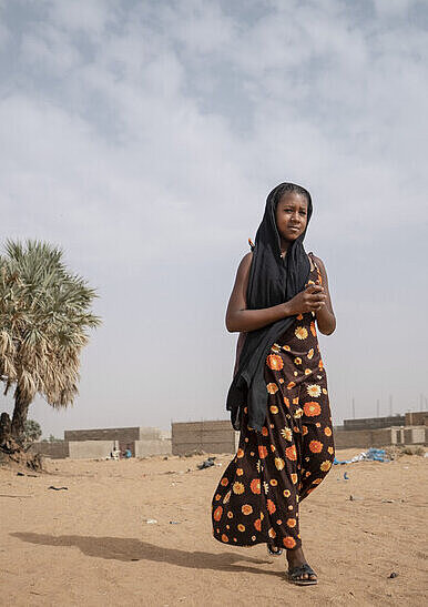 Aminata geht von der Schule nach Hause Mädchen läuft über eine sandige Straße