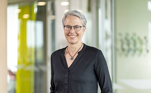 Kirstin Bostelmann, Gender-Expertin von Plan International Deutschland Eine Frau steht in einem Büroflur