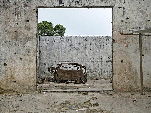 Einschusslöcher wie an diesem Gebäude erinnern an die Folgen von jahrelangen Bürgerkriegen in Liberia Ein verlassenes Haus voller Einschusslöcher und ein ausgebranntes Autowrack