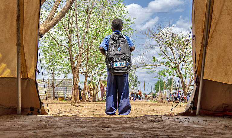 Ein Junge steht in einem Zelt in einem Campt für geflüchtete Menschen in Sudan Krisenherd Sudan Schwerpunkte Der Konflikt in Sudan gilt international als eine vernachlässigte Krise, über die kaum berichtet wird. Dabei hat der seit dem 15. April 2023 tobende Krieg die größte humanitäre Krise weltweit ausgelöst, die Millionen Kinder und Frauen bedroht.