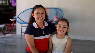 Ein kleines Mädchen und ihre Mutter sitzen auf der Veranda