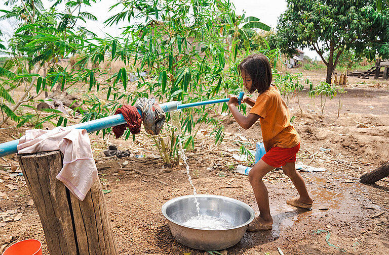 Ein Mädchen pumpt Wasser